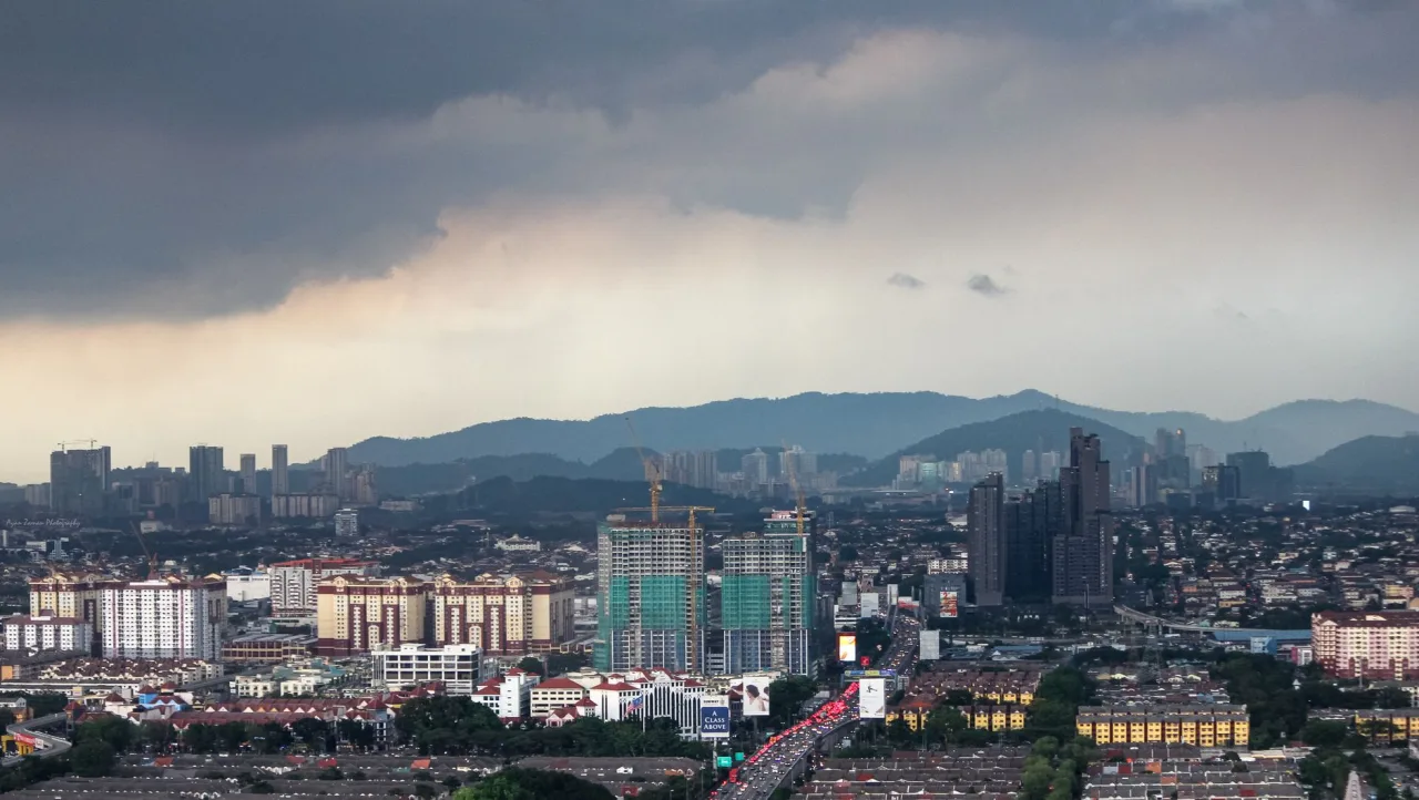 Subang Jaya skyline and residential districts beneath storm clouds.